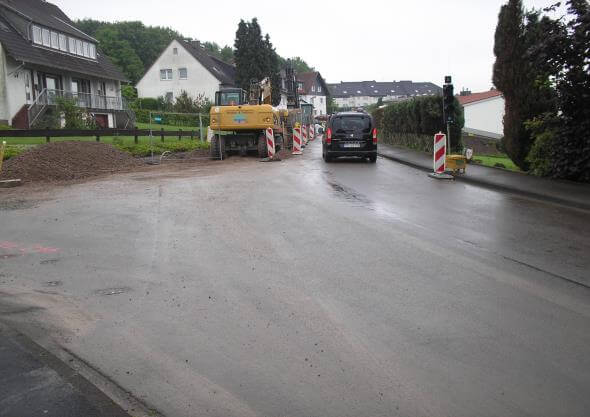 Bauarbeiter verlegen Asphalt auf der Birkeshöhstraße während des Straßenausbaus in NRW.